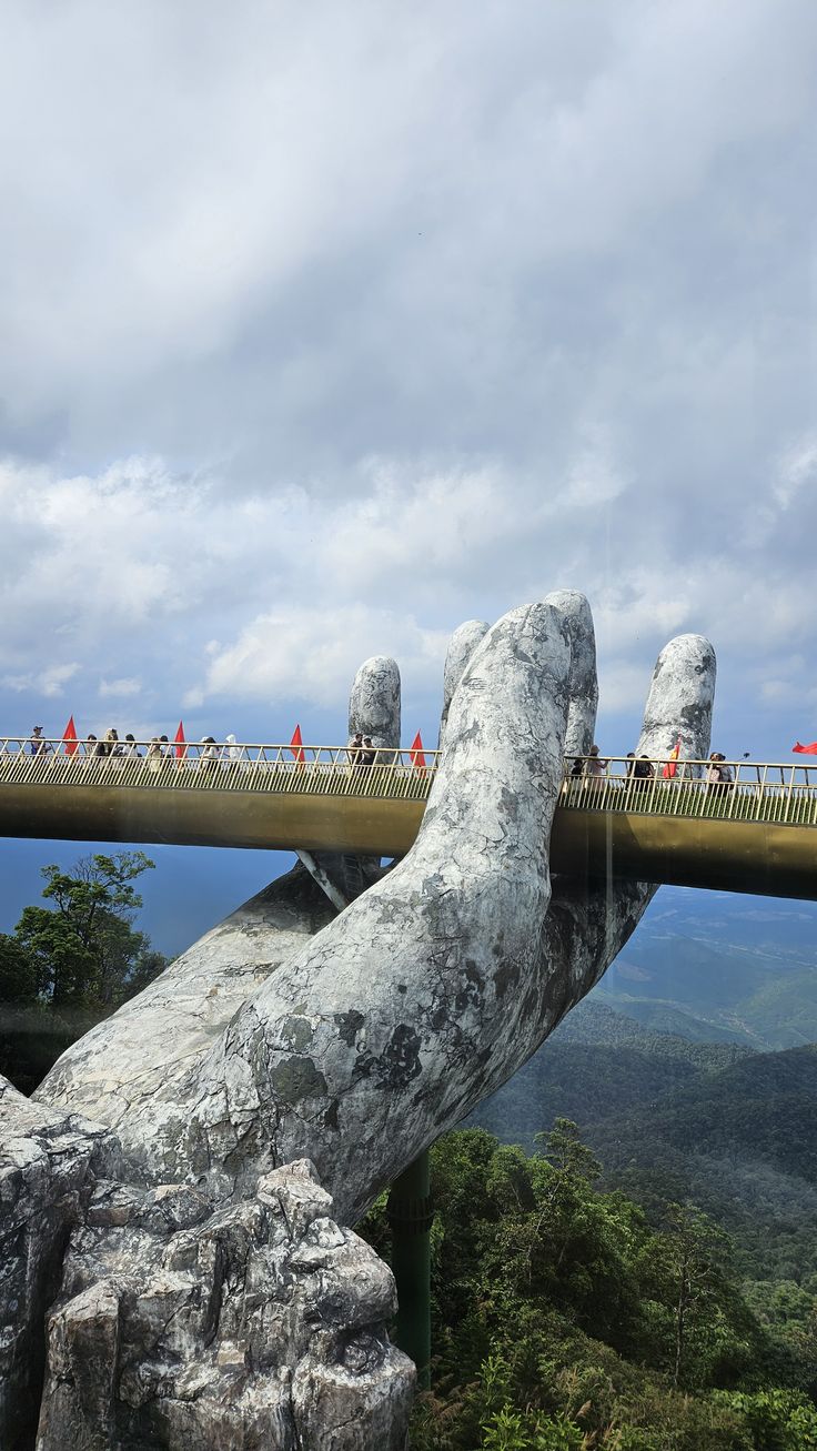 The Golden Bridge held by giant stone hands above the misty Ba Na Hills near Da Nang